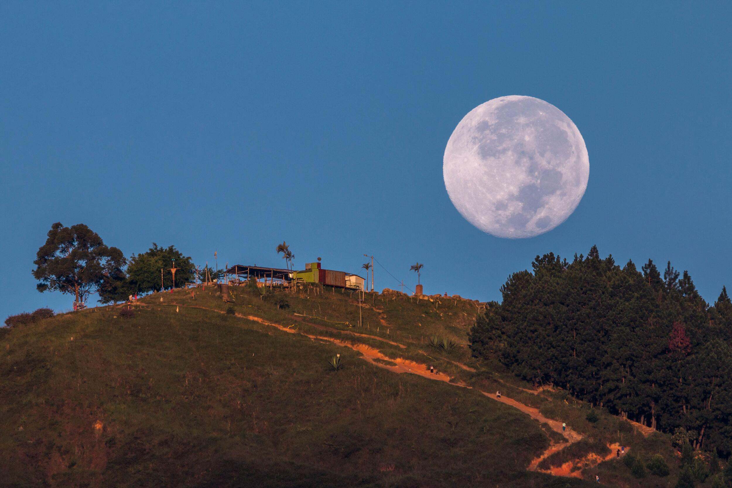 Ascent to heaven // Photograph of the Tres Cruces mountain at dawn as the moon descended over the horizon in the city of Medellin, Antioquia, Colombia, June 18, 2019.